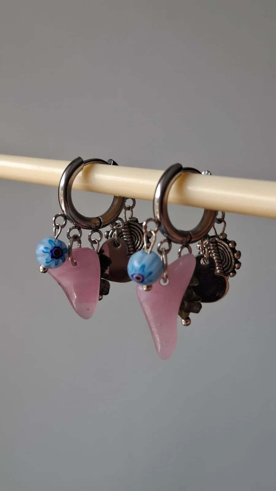 Boucles d'oreilles suspendues ornées de morceaux de verre rose arrondis, perles bleues et breloques.