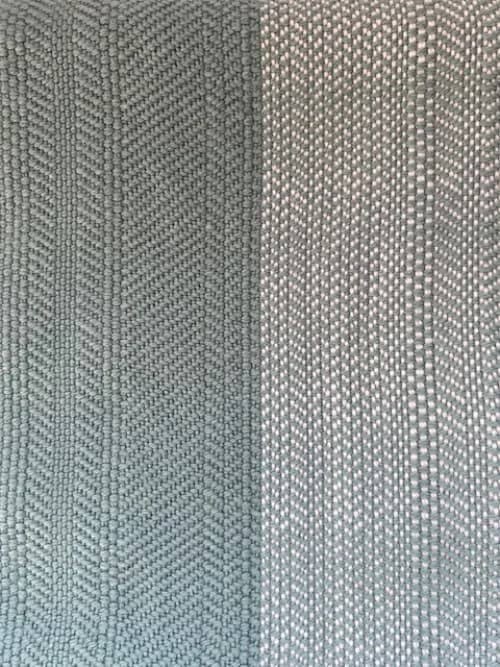 Gros plan sur le tissage texturé aux motifs chevrons d'une écharpe vert sauge.