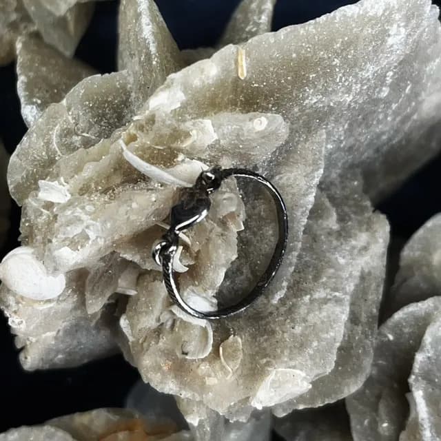 Vue de profil d'une bague fine argentée avec motif cœur sur une pierre